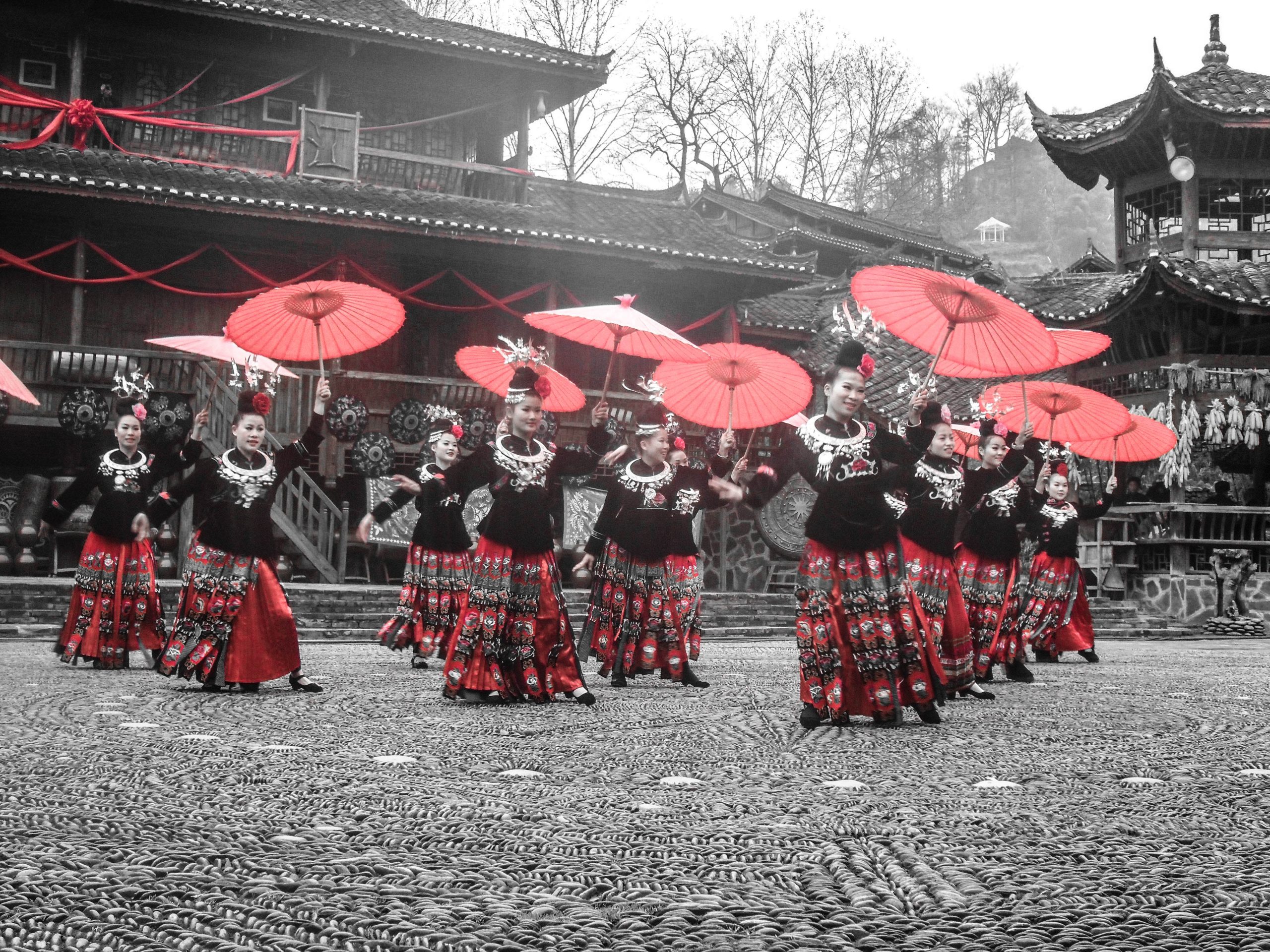 Traditional womens dance with beautiful red umbrellas